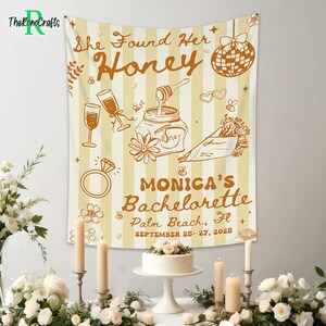 May include: A beige and white striped tapestry with the text "She Found Her Honey" and "Monica's Bachelorette Palm Beach, Fl September 25-27, 2025". The design includes illustrations of champagne glasses, a ring, and a disco ball.
