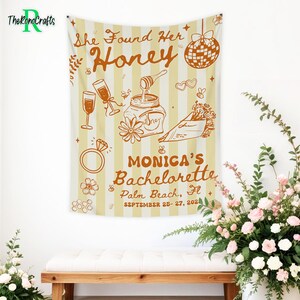 May include: A beige and white striped tapestry with the text "She Found Her Honey" and "Monica's Bachelorette Palm Beach, FL September 25-27, 202" in brown. The tapestry features illustrations of champagne glasses, a ring, and a disco ball.