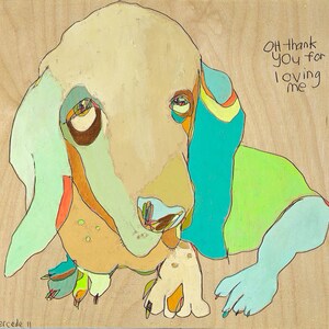 May include: A colorful painting of a dog with the text "Oh thank you for loving me". The dog is painted in shades of green, blue, yellow, and orange. The background is a light wood color.