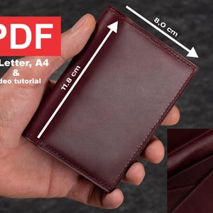 May include: A burgundy leather wallet with a stitched edge. The wallet measures 11.8 cm by 8.0 cm.
