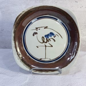 Puede incluir: Un juego de tres tazas de cerámica con un acabado mate moteado. Las tazas son de color crema, gris claro y gris oscuro. Cada taza tiene un diseño minimalista y un asa redondeada.