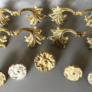 May include: A set of three ceramic mugs with a speckled, matte finish. The mugs are in shades of cream, light gray, and dark gray. Each mug has a simple, minimalist design and a rounded handle.