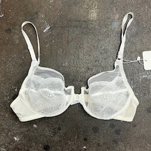 Sutiã bralette de renda branca Yves Saint Laurent, estilo anos 80/90, com pingente com monograma YSL, tamanho 36B.
