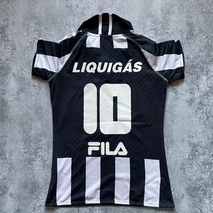 Puede incluir: Camiseta Liquigas en blanco y negro con el n&uacute;mero 10 y el logo de Fila. La camiseta tiene rayas blancas en las mangas y en la parte inferior, y la palabra "Liquigas" est&aacute; impresa en la parte superior de la espalda.