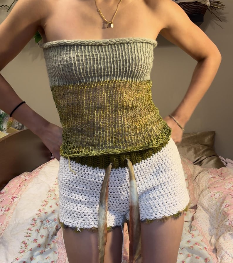 May include: A green and white crocheted tube top with a white crocheted skirt. The top is a halter style and the skirt is a high-waisted style.