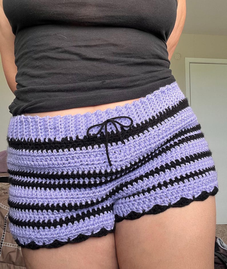 May include: Purple and black striped crochet shorts with a scalloped hem.
