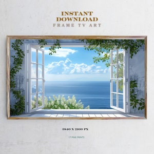 Op de afbeelding: Een ingelijste digitale kunstprint van een raam met witte bekleding en groene wijnstokken, uitkijkend op een blauwe oceaan met witte wolken in de lucht. De tekst "INSTANT DOWNLOAD FRAME TV ART" staat bovenaan de afbeelding. De tekst "3840 X 2160 PX 17 PINE PRINTS" staat onderaan de afbeelding.
