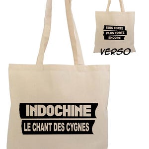 Peut inclure: Un sac fourre-tout en toile blanche avec du texte noir qui dit "Indochine Le Chant Des Cygnes". Le dos du sac a du texte noir qui dit "Sois Forte Plus Forte Encore".