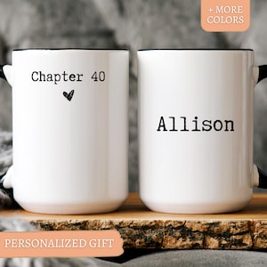 May include: Two white ceramic mugs with black rims and handles. One mug says "Chapter 40" with a heart, the other says "Allison". The mugs are on a wooden surface. Text at the bottom says "PERSONALIZED GIFT".
