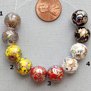 May include: Ten round beads with gold and iridescent floral patterns on a white background. The beads are arranged in a circle, with the numbers 1 through 5 printed on the background. The beads are in the following colors: gray, yellow, red, white, and black.