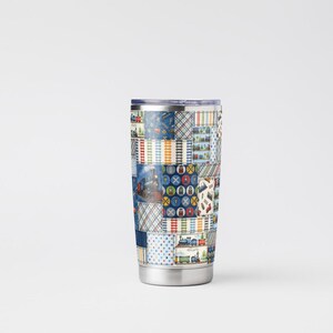 K&ouml;nnte beinhalten: Ein Reisebecher aus Edelstahl mit einem Patchwork-Design. Das Patchwork-Muster zeigt verschiedene Bilder und Muster in Blau-, Rot-, Gelb- und Wei&szlig;t&ouml;nen. Der Becher hat einen silbernen Boden und einen silbernen Rand.