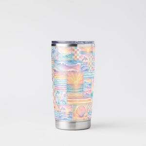 Pode incluir: Um copo de viagem em a&ccedil;o inoxid&aacute;vel com um design de patchwork colorido. O padr&atilde;o apresenta ilustra&ccedil;&otilde;es em aquarela de cenas oce&acirc;nicas, incluindo pores do sol, ondas, golfinhos e conchas. O copo tem uma tampa e base prateadas.