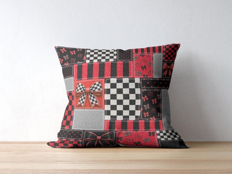 May include: A square throw pillow featuring a patchwork design of red, black, white, and gray panels. The pattern includes alternating sections of checkered squares, vertical stripes, and small bow motifs, with a prominent 3D-style bow graphic.