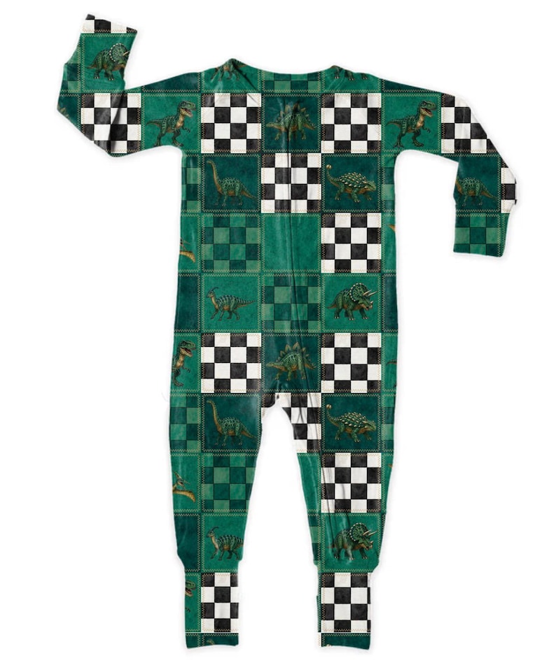 May include: Green and black dinosaur-themed one-piece pajama set. The pajamas feature a checkered pattern with various dinosaur illustrations. The long-sleeved, full-length sleepwear is designed for comfort and warmth. The color palette includes shades of green, black, and white.