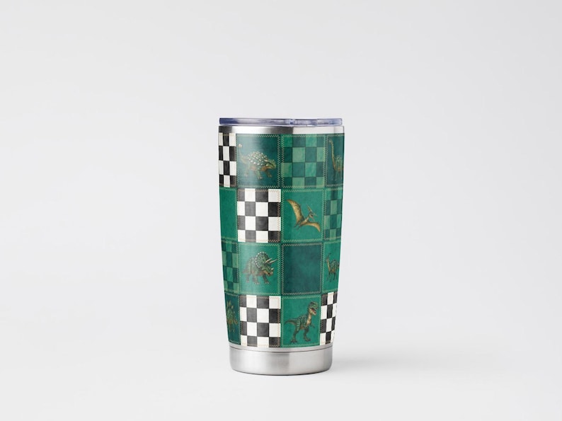 May include: Stainless steel travel tumbler with a green and black checkered pattern. The design features various dinosaurs. The tumbler has a silver rim and base, and a clear lid. The overall theme is dinosaurs.