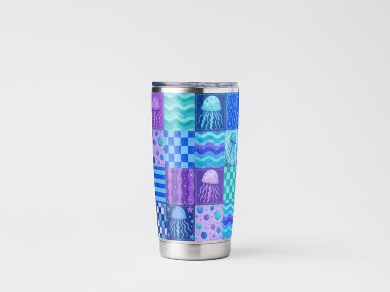 May include: A stainless steel travel mug with a patchwork design featuring jellyfish in shades of blue, purple, and teal. The pattern includes checkerboard, wavy lines, and polka dots. The mug has a silver rim and base.