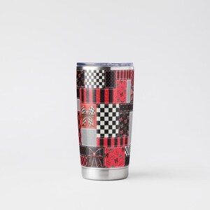 May include: A stainless steel tumbler featuring a patchwork design of red, black, and silver squares. The pattern includes black and white checkered squares, red and black stripes, and red squares decorated with small black bows and butterfly motifs.