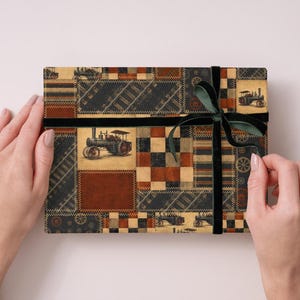 Peut inclure: Une bo&icirc;te cadeau rectangulaire envelopp&eacute;e dans du papier &agrave; motif patchwork repr&eacute;sentant des tracteurs &agrave; vapeur anciens, des voies ferr&eacute;es et des carr&eacute;s g&eacute;om&eacute;triques dans des tons marron, noir et cr&egrave;me, nou&eacute;e d'un ruban en velours vert fonc&eacute;.