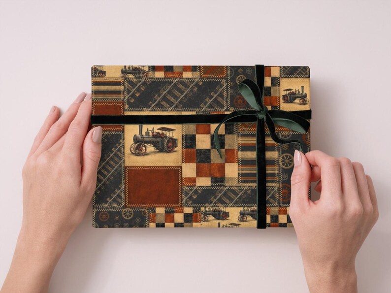 Peut inclure: Une bo&icirc;te cadeau rectangulaire envelopp&eacute;e dans du papier &agrave; motif patchwork repr&eacute;sentant des tracteurs &agrave; vapeur anciens, des voies ferr&eacute;es et des carr&eacute;s g&eacute;om&eacute;triques dans des tons marron, noir et cr&egrave;me, nou&eacute;e d'un ruban en velours vert fonc&eacute;.