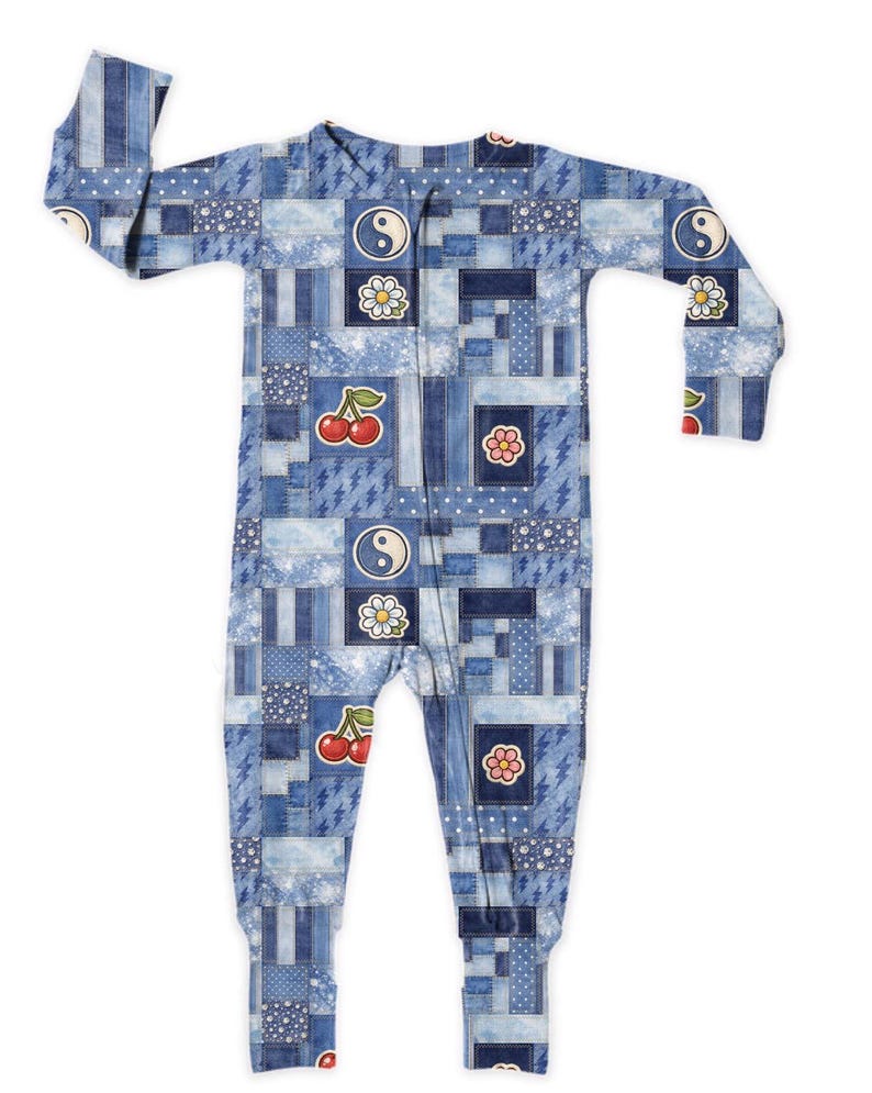 Op de afbeelding: Blauwe patchwork-voetpyjama met ritssluiting. De eendelige nachtkleding heeft een verscheidenheid aan denim-stijl patronen, met kersen-, bloemen- en yin-yang graphics. De pyjama met lange mouwen is ontworpen voor comfort en stijl.