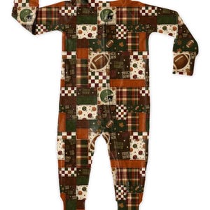 May include: A one-piece football-themed pajama set. The sleepwear features a patchwork design with footballs, helmets, and the words "Touch Down" and "Game Day". The color palette includes shades of brown, green, and orange.