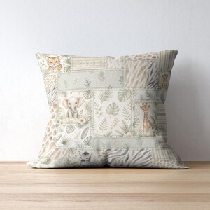 May include: Square decorative pillow with a patchwork design featuring watercolor illustrations of safari animals, including a tiger, elephant, and giraffe. The pillow has a neutral color palette with green and beige tones.