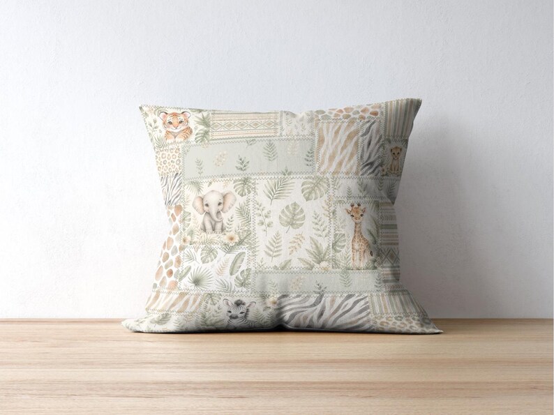 May include: Square decorative pillow with a patchwork design featuring watercolor illustrations of safari animals, including a tiger, elephant, and giraffe. The pillow has a neutral color palette with green and beige tones.