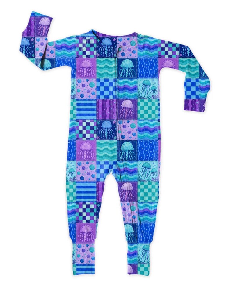 May include: A patterned sleepsuit in a patchwork design. The all-in-one garment features a repeating pattern of jellyfish, wavy lines, and polka dots in blue, purple, and teal. The sleepsuit has a zip down the front.