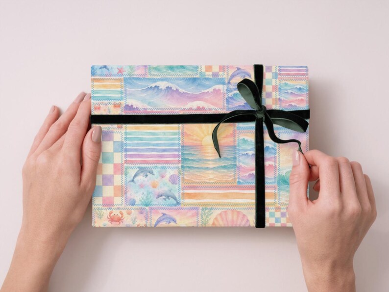 Pode incluir: Uma caixa de presente retangular embrulhada em papel aquarela colorido com cenas oce&acirc;nicas, golfinhos e um p&ocirc;r do sol. A caixa &eacute; amarrada com uma fita de veludo preta e um la&ccedil;o verde escuro.