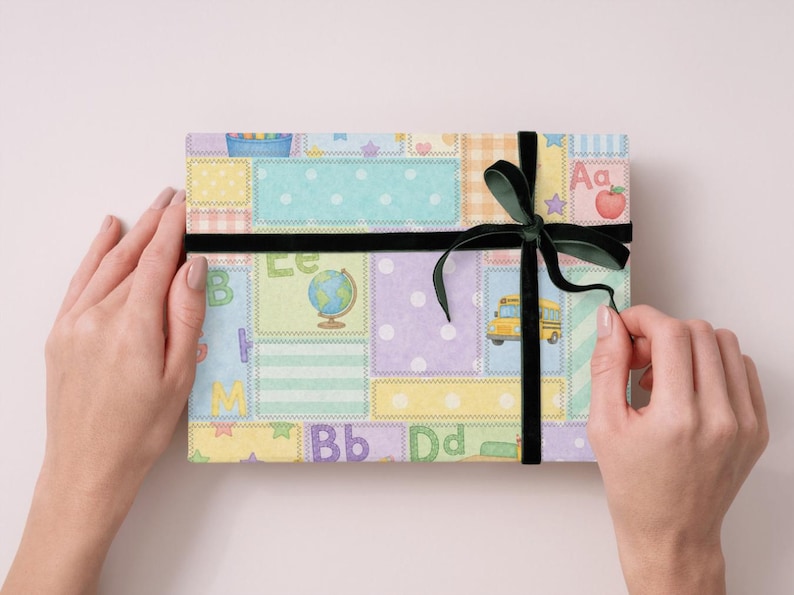 May include: A present wrapped in paper with a patchwork design featuring school-themed illustrations. The gift is tied with a black velvet ribbon and bow. The illustrations include a school bus, globe, and apple.