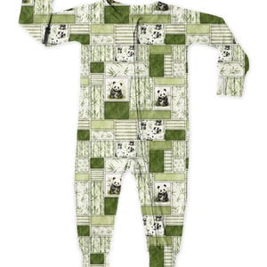 May include: A green and white patchwork pajama set featuring panda bears and bamboo stalks. The one-piece sleepwear has a zipper closure and long sleeves. The design includes various shades of green and white, creating a cozy and playful look.