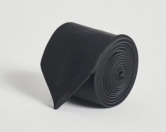 Seine Breite beträgt 7,5 cm. 100% Polyester, schwarze Krawatte
