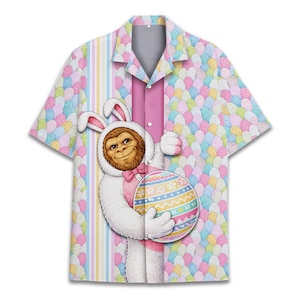 May include: Short-sleeved button-down shirt featuring a whimsical Easter-themed design. The shirt showcases a cartoon Bigfoot character in a bunny costume holding a decorated Easter egg. The background is a pattern of pastel-colored Easter eggs.