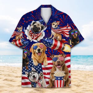 Op de afbeelding: Blauw overhemd met een patriottisch hondenthema. Het shirt toont verschillende hondenrassen met zonnebrillen en patriottische accessoires, tegen een achtergrond van vuurwerk en een Amerikaanse vlag.