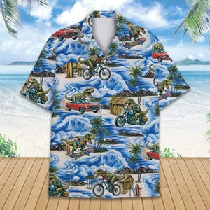 May include: Short-sleeved button-down shirt with a tropical beach scene featuring dinosaurs riding bicycles, motorcycles, and skateboards. The shirt has a blue background with white waves, palm trees, and red cars.