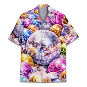 May include: Short-sleeved button-down shirt featuring a vibrant all-over print of disco balls in various colors, including silver, gold, pink, purple, and blue. The shirt has a classic collar and a button-up front, perfect for a retro or party-themed look.