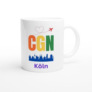 Könnte beinhalten: Weiße Keramik-Kaffeetasse mit einem regenbogenfarbenen CGN und dem Wort "Köln" darauf gedruckt. Ein rotes Flugzeug mit einem herzförmigen Schweif fliegt über den Buchstaben. Eine Silhouette der Kölner Skyline befindet sich unter den Buchstaben.