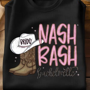 May include: Black sweatshirt with a graphic design featuring a white cowboy hat with "BRIDE" on it, brown cowboy boots, and the words "NASH BASH Bachelorette" in pink.