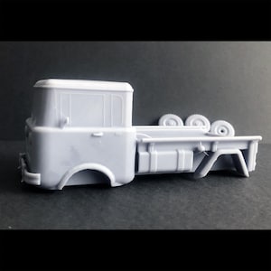 May include: A white plastic model of a vintage pickup truck with a flatbed and four wheels. The truck has a cab with a windshield and a door on the driver's side.
