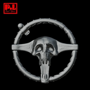 May include: A silver-colored steering wheel with a skull design in the center. The wheel has a circular shape with a series of small, raised studs around the rim. The text "P.L. For You" is in a red square in the upper left corner.
