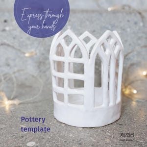 Puede incluir: Una plantilla de cerámica blanca con un diseño de ventana de catedral. La plantilla tiene una base cilíndrica y una parte superior calada. El texto "Express through your hands" está en un círculo azul, y "Pottery template" está debajo.