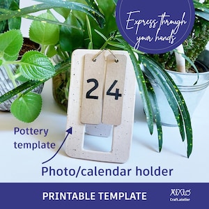 Może przedstawiać: Drukowany szablon na ceramiczny stojak na zdjęcia lub kalendarz. Szablon ma nakrapiane białe tło z prostokątnym wycięciem na zdjęcie lub kalendarz. Szablon zawiera również dwa prostokątne pola na liczby, z wyświetloną liczbą "24" w kolorze czarnym.