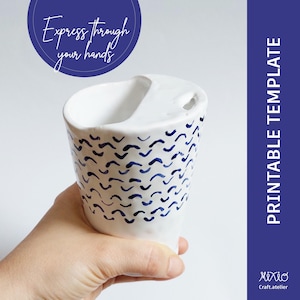 May include: White ceramic mug with a blue and white wavy pattern. The mug has a unique handle and a cutout on the side. "Express through your hands" is written on a blue circle in the background.