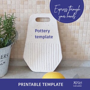 Puede incluir: Plantilla de cerámica imprimible para una bandeja de servir de cerámica blanca con un acabado moteado. La plantilla incluye un asa y un diseño en relieve. El texto "Pottery template" está impreso en la bandeja.