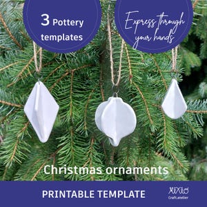Pode incluir: Três modelos de enfeites de Natal de cerâmica branca, incluindo um formato de diamante, um formato de lágrima e um formato redondo com cinco pontas. Os enfeites estão pendurados em um barbante em um galho de pinheiro verde. O texto "Express through your hands" está em um círculo azul acima dos enfeites. O texto "3 Pottery templates" está em um círculo azul acima do enfeite em formato de diamante. O texto "Christmas ornaments PRINTABLE TEMPLATE" está em uma faixa azul abaixo dos enfeites. O texto "Mixio Craft.atelier" está em uma faixa branca abaixo da faixa azul.