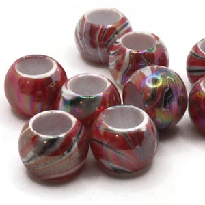 May include: A group of ten red, white, and black swirl patterned plastic beads. The beads have a hole in the center and are designed for use in jewelry making or crafts.
