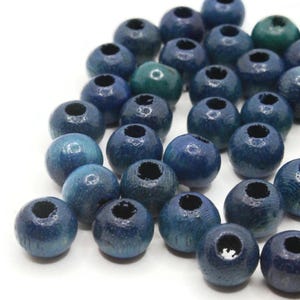 May include: A collection of blue wooden beads with a hole in the center. The beads are round and have a smooth, polished finish.