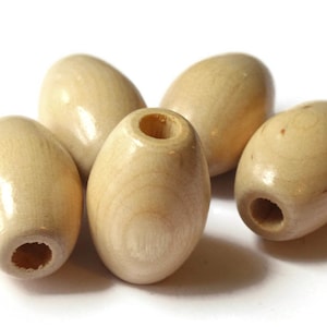 以下が含まれることがあります： 中央に穴の開いた、自然な木の楕円形のビーズが5つあります。ビーズは薄いベージュ色で、滑らかで磨かれた仕上げになっています。