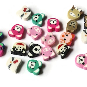 May include: A collection of colorful animal-shaped beads, including a pig, cat, bear, and monkey. The beads are made of plastic and have a glossy finish.