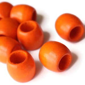 May include: A group of eight orange wooden beads with a hole in the center. The beads are smooth and have a glossy finish.
